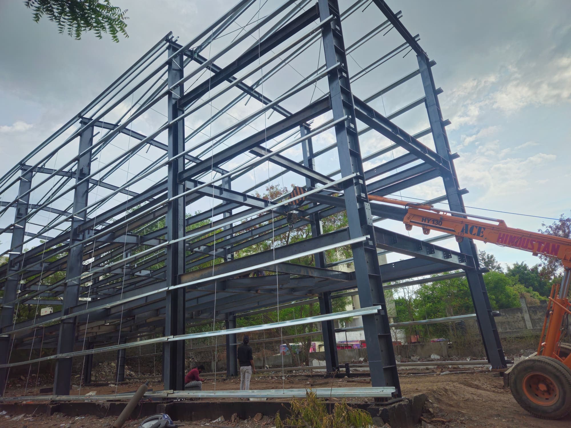 Multi-storey steel frame of the stockyard with a mobile crane alongside