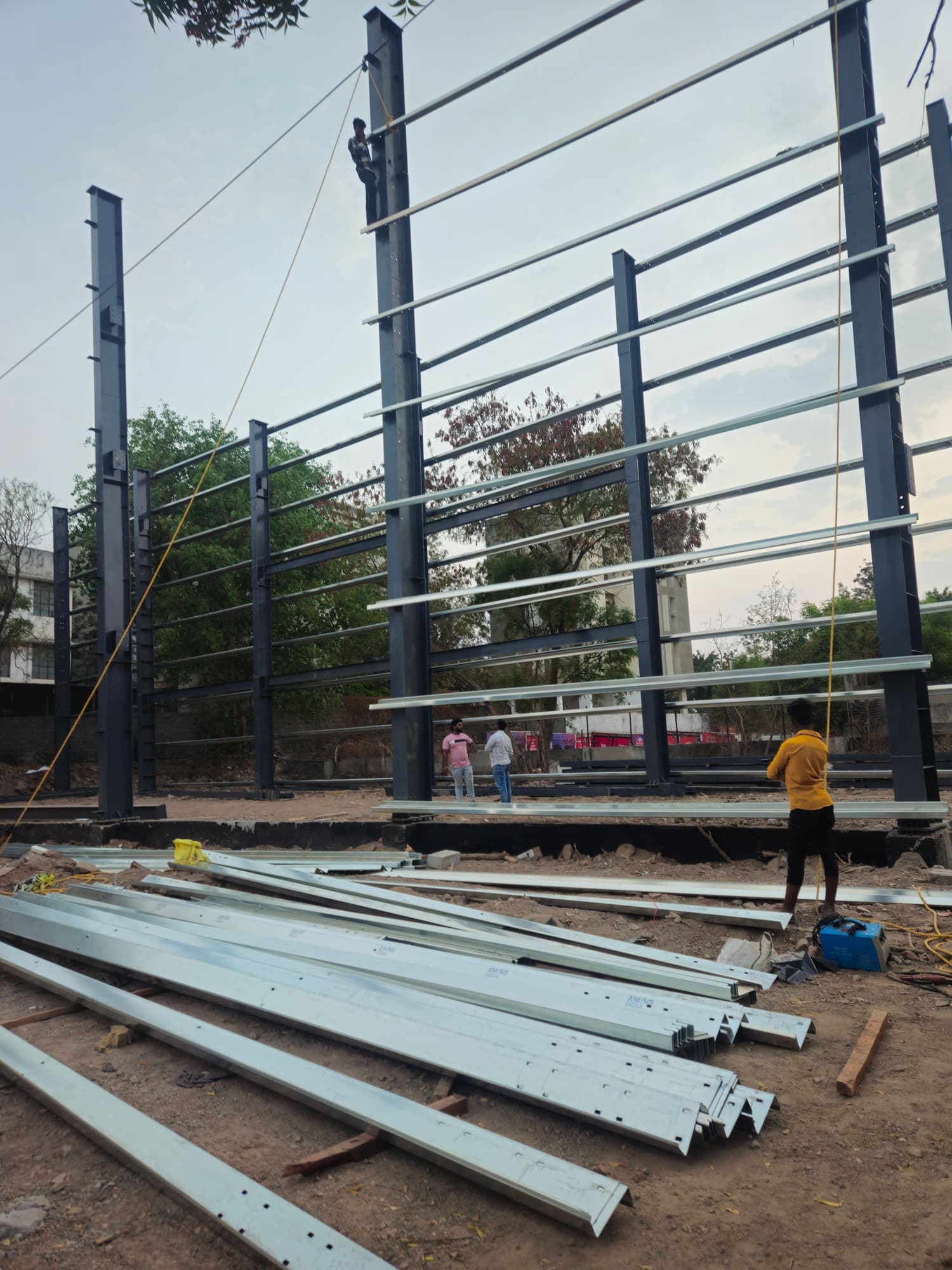 Cold-formed purlins laid out beside the rising steel frame