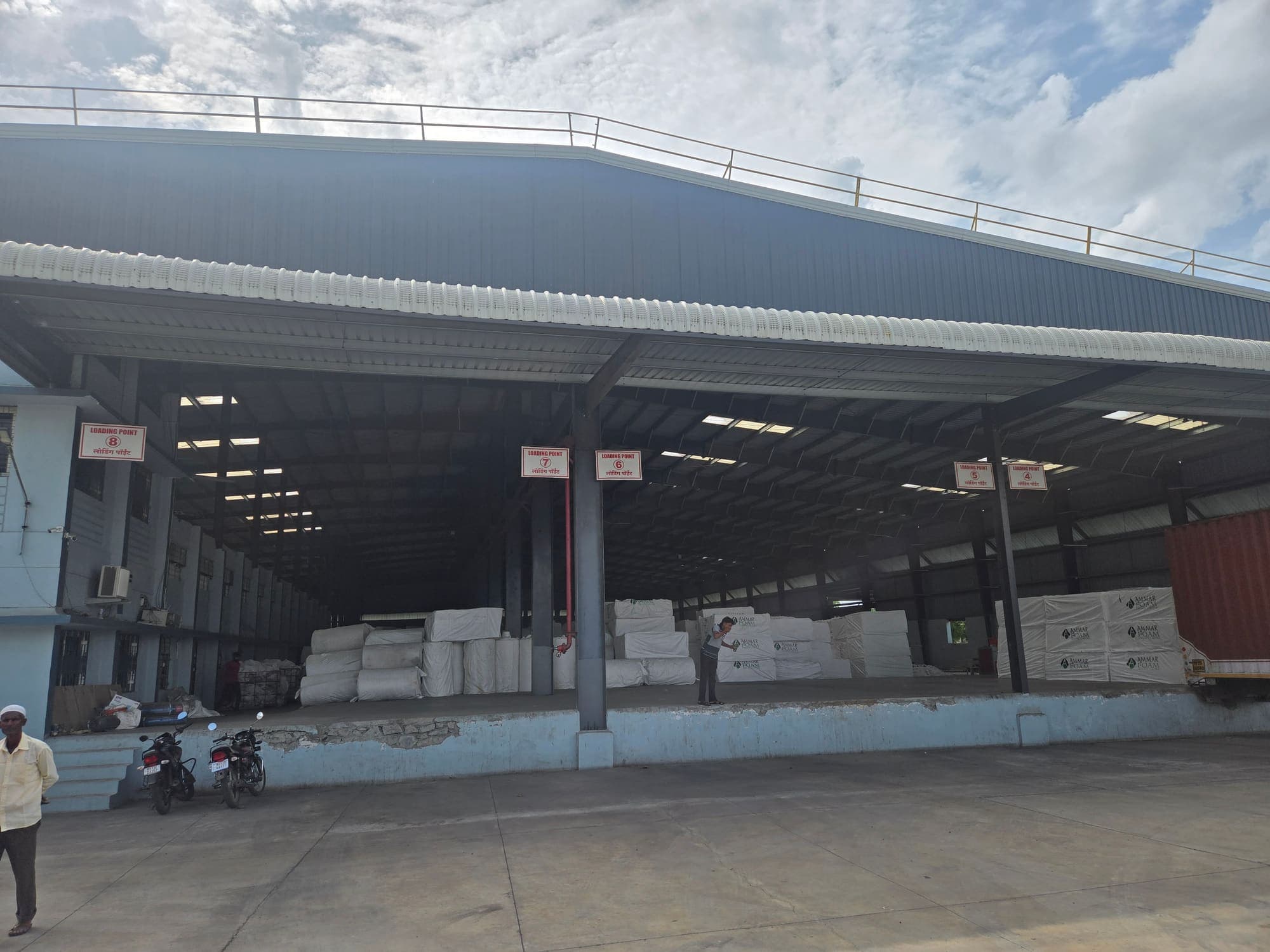Stockyard with a long loading canopy and trucks at the platform